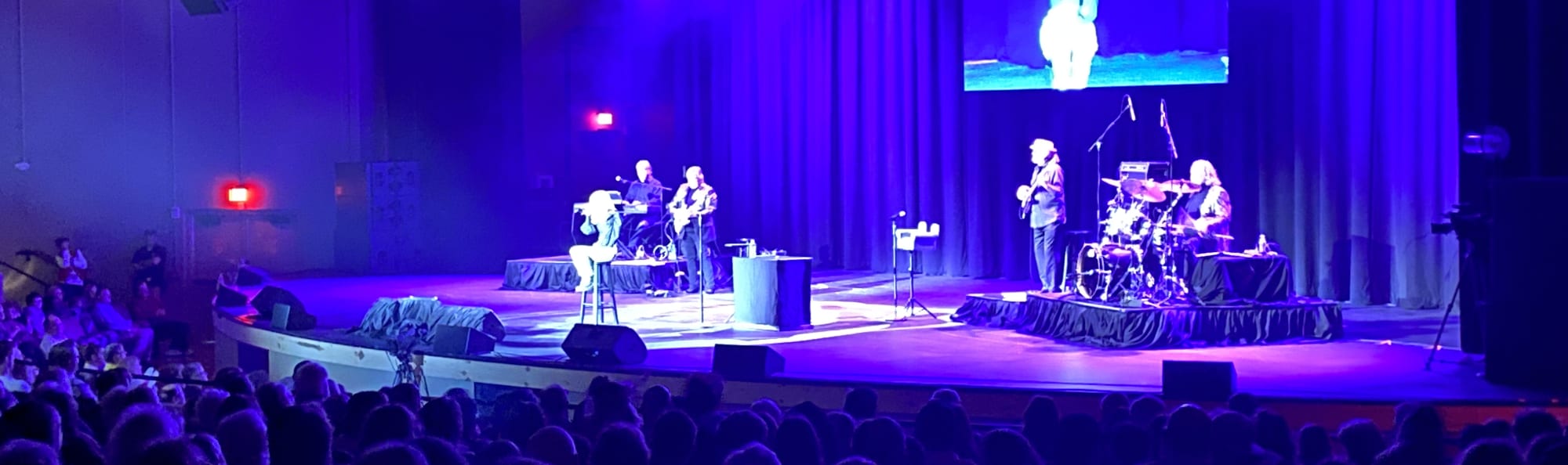 signer on stage in chair washed out by the lights Oklahoma City